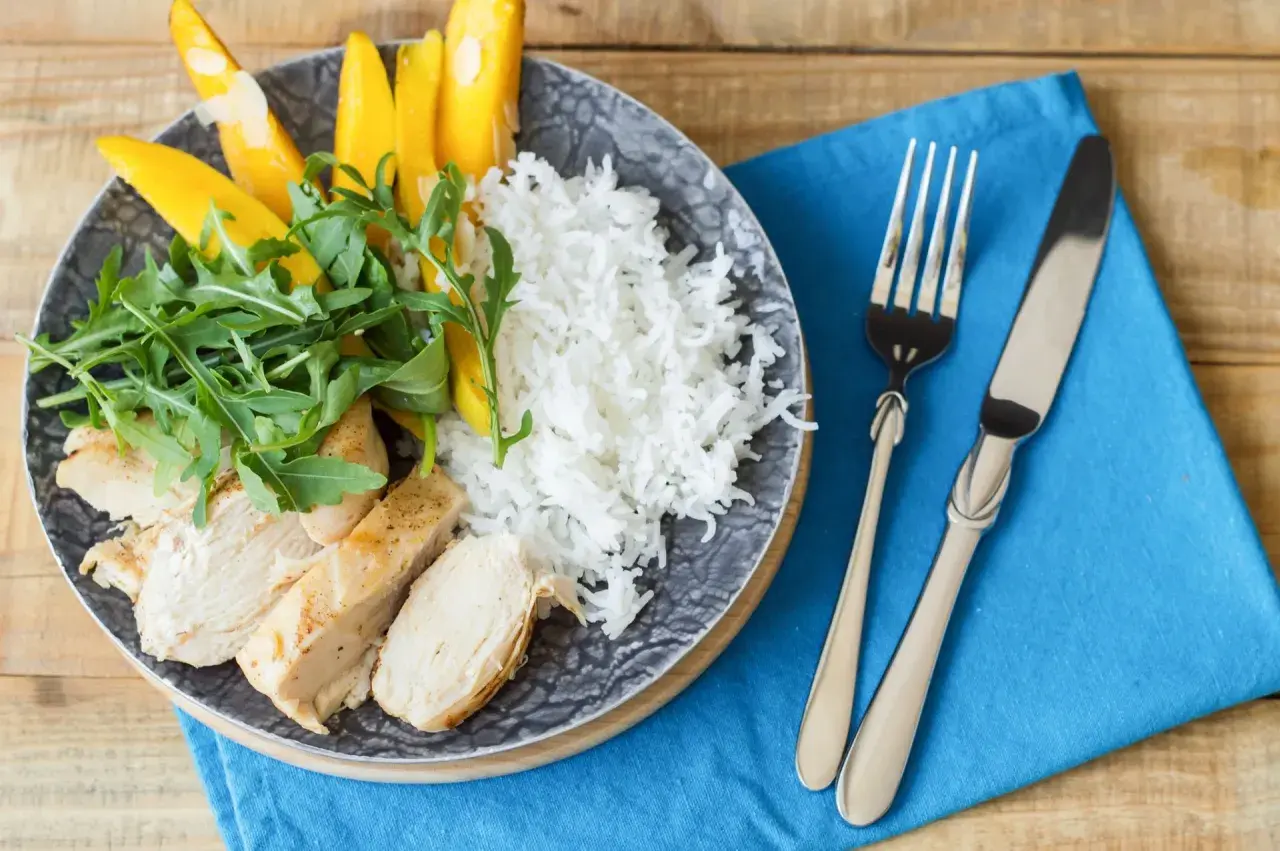 Idealny posiłek po treningu: grillowany kurczak, ryż, mango i rukola. Zdrowo i smacznie!